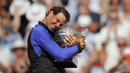 Rafael Nadal memeluk trofi juara usai mengalahkan petenis Swis, Stan Wawrinka  pada laga Final Tunggal Putra, Prancis Terbuka 2017 di Roland Garros stadium, Paris, (11/6/2017). Nadal menang  6-2, 6-3, 6-1. (AP/Christophe Ena)