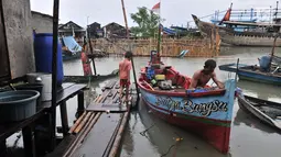 Nelayan beraktivitas saat banjir rob menggenangi permukiman Muara Angke, Jakarta, Selasa (22/1). Banjir air laut pasang atau Rob yang kembali melanda kawasan itu sejak 6 hari lalu membuat aktivitas warga sekitar terganggu. (Merdeka.com/Iqbal S. Nugroho)