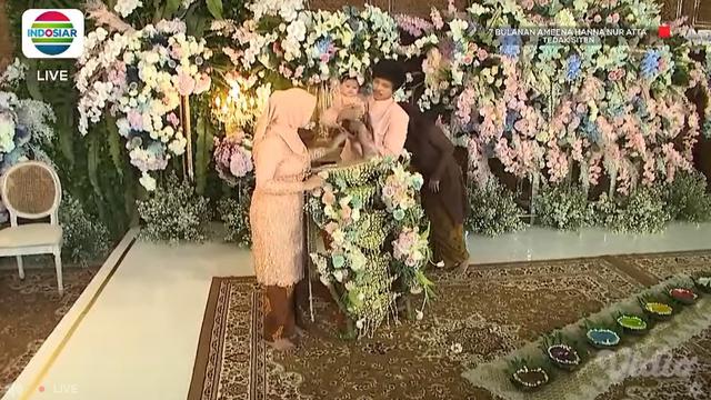 Atta Halilintar dan Aurel Hermansyah mendampingi putri mereka Ameena Hanna Nur Atta menjalani upacara Tedak Siten di acara 7 bulanan. (Foto: Indosiar/Vidio)