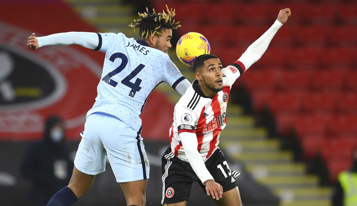 Bek Chelsea, Reece James (kiri) berebut bola udara dengan pemain Sheffield United, Max Lowe pada pertandingan lanjutan Liga Inggris di stadion Bramall Lane, Inggris, Senin (8/2/2021). Chelsea menang tipis atas Sheffield United 2-1. (Clive Mason/ Pool via AP)