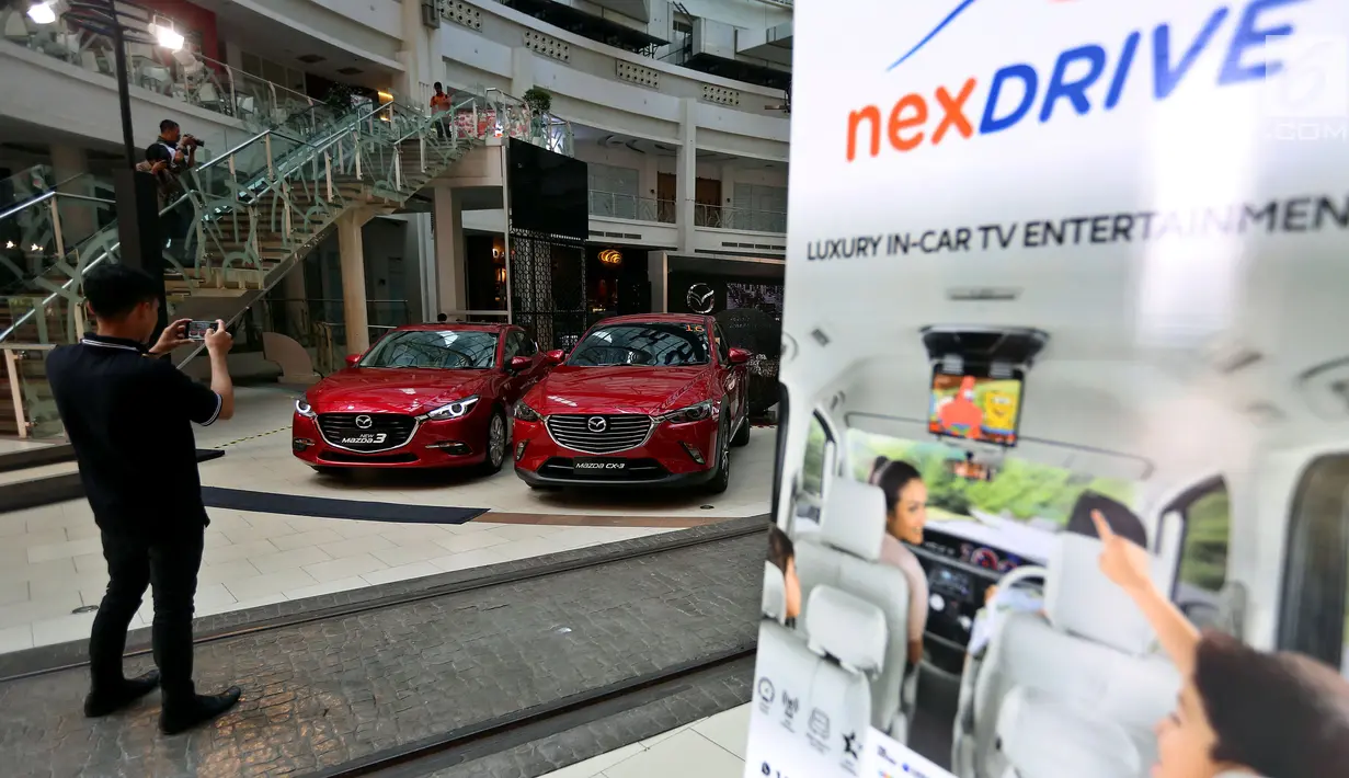 Pengunjung mengambil gambar mobil New Mazda 3 dan Mazda CX3 saat pagelaran Mazda Power Drive 2017 di Epiwalk, Kuningan, Jakarta, Sabtu (21/10). (Liputan6.com/JohanTallo)