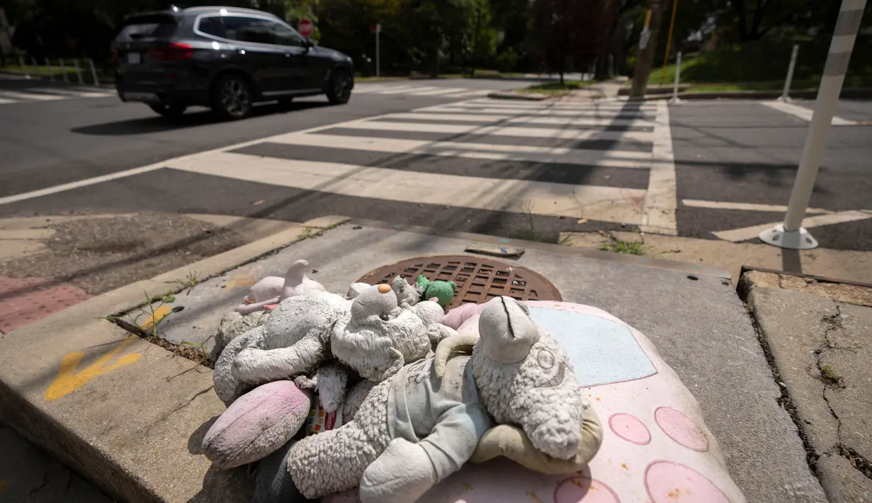 Boneka putih kecil diletakkan di jalan Irving dan 14th, Timur Laut, di Washington, DC, memberikan penghormatan kepada Allie Hart, 5 tahun, yang tertabrak dan meninggal dunia di tempat penyeberangan ini pada tahun 2021. (AP Photo/Mark Schiefelbein)