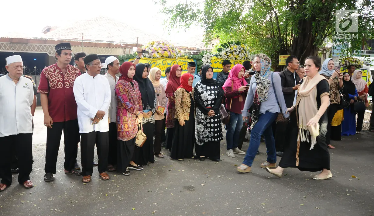 Warga berjajar melepas kepergian mobil jenazah yang membawa peti jenazah Asmaniah, istri Wakil Presiden ke-9 RI, Hamzah Haz di Jakarta, Selasa (12/9). Jenazah akan dimakamkan di pemakaman keluarga di Bogor, Jawa Barat. (Liputan6.com/Helmi Fithriansyah)