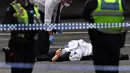 Polisi memeriksa jasad di TKP setelah insiden penikaman di Melbourne, Australia, Jumat (9/11). Akibat penyerangan ini satu orang tewas dan dua lainnya luka-luka. (William WEST/AFP)