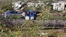 Teman dan keluarga berdoa di luar rumah mobil yang rusak di Flatwood, Alabama, Rabu (30/11/2022). Badai Tornado melanda daerah tersebut yang mengakibatkan dua orang tewas di komunitas Flatwood di utara kota Montgomer. (AP Photo/Butch Dill)