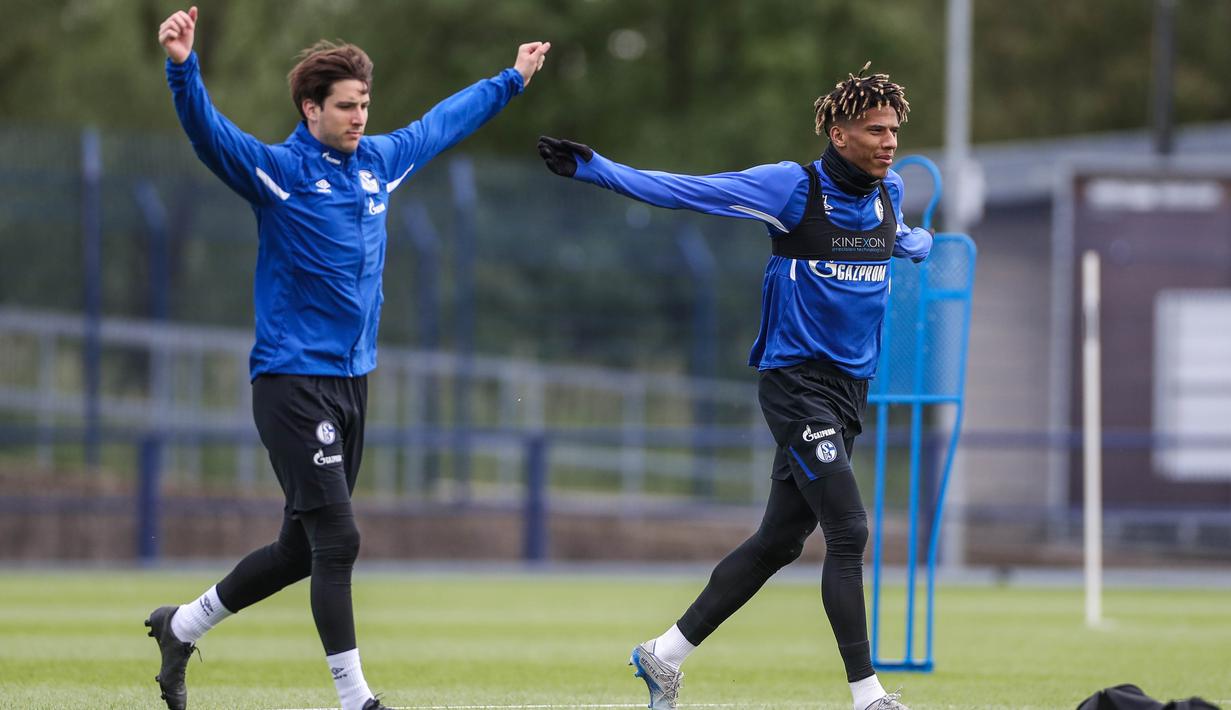 Pemain Schalke 04, Juan Miranda dan Jean-Clair Todibo, melakukan latihan di Gelsenkirchen (12/5/2020). Sejumlah klub menggelar latihan jelang bergulirnya kembali liga-liga di Eropa. (AFP/Tim Rehbein)