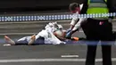 Polisi memeriksa jasad di TKP setelah insiden penikaman di Melbourne, Australia, Jumat (9/11). Pelaku penyerangan, teroris Somalia yang diidentifikasi sebagai Mohamed Khalif ditembak mati dalam kejadian tersebut. (William WEST/AFP)