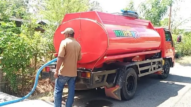 Mobil tangki sedang mengisi air di rumah warga. (Liputan6.com/Dionisius Wilibardus)