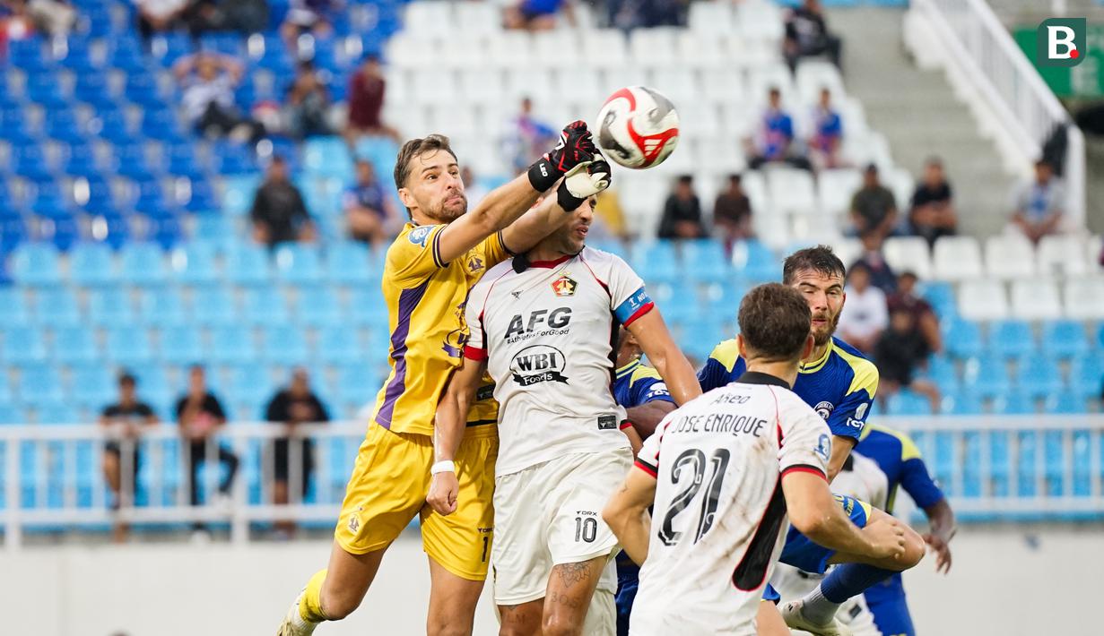 Kiper Arema FC, Lucas Frigeri berduel udara dengan pemain Persik Kediri, Ezra Walian dalam laga lanjutan BRI Super League 2025/2026 di Stadion Kanjuruhan, Malang, Minggu (11/01/2026). (Bola.com/Iwan Setiawan)