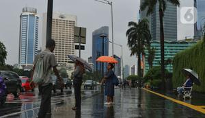 Warga menggunakan payung saat hujan mengguyur kawasan Jakarta, Senin (3/2/2020). Badan Meteorologi, Klimatologi, dan Geofisika (BMKG) merilis informasi peringatan dini cuaca ekstrem yang diperkirakan berlangsung hingga Rabu (5/2/2020) mendatang. (Liputan6.com/Angga Yuniar)