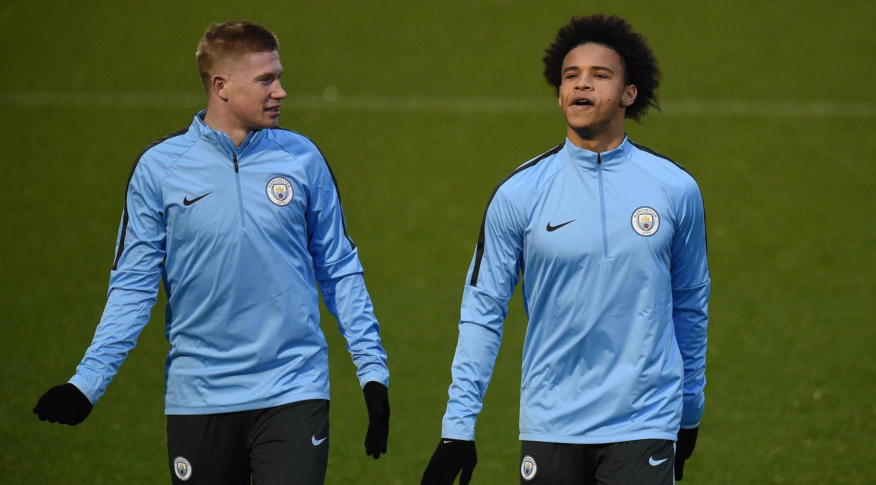 Gelandang Manchester City, Kevin De Bruyne (kiri) dan Leroy Sane melakukan pemanasan saat mengikuti latihan jelang menghadapi Feyenoord di Liga Champions  di Manchester, Inggris (20/11). (AFP Photo/Oli Scarff)