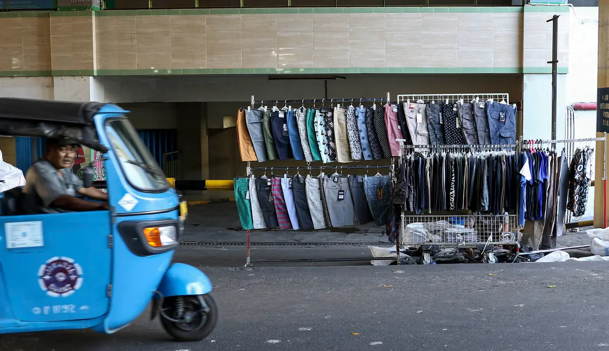 Bajaj melintas di depan Gedung Pasar Tanah Abang, Jakarta, Jumat (22/6). Sebagian pedagang terpaksa menggelar lapak di luar gedung akibat belum dibukanya kembali Pasar Tanah Abang usai Lebaran. (Liputan6.com/Immanuel Antonius)