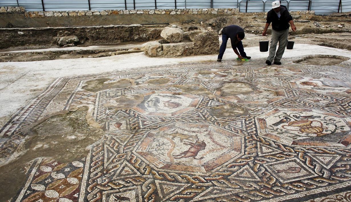 Seorang peneliti sejarah kuno membersihkan sebuah gambar yang ada pada lantai sebuah peradaban pada 1.700 tahun yang lalu di Tel Aviv, Israel, Senin (16/11/2015). Tempat ini telah ada pada zaman Romawi dan periode Bizantium.  (REUTERS/Nir Elias)