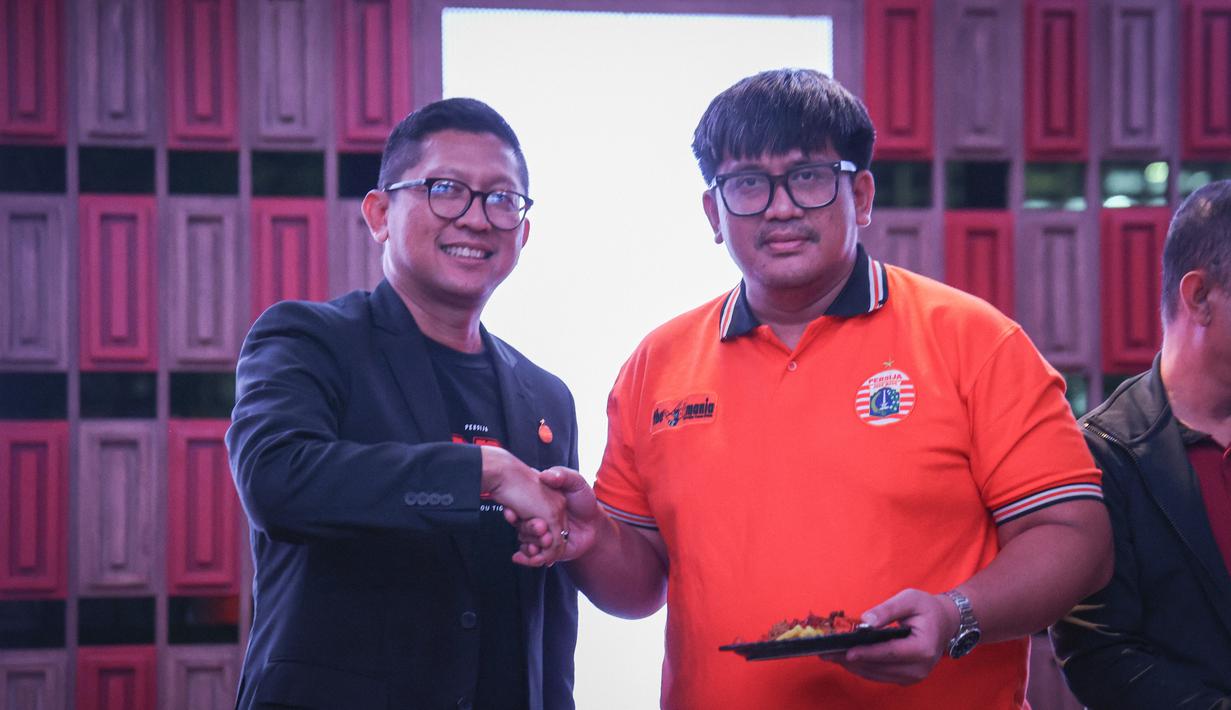 Direktur Persija Jakarta, Mohamad Prapanca (kiri) memberikan potongan tumpeng kepada Ketua Umum Jakmania, Diky Soemarno pada acara perayaan Hari Ulang Tahun Persija ke-96 di Trinity Tower, Jakarta, Kamis (28/11/2024). (Bola.com/Abdul Aziz)