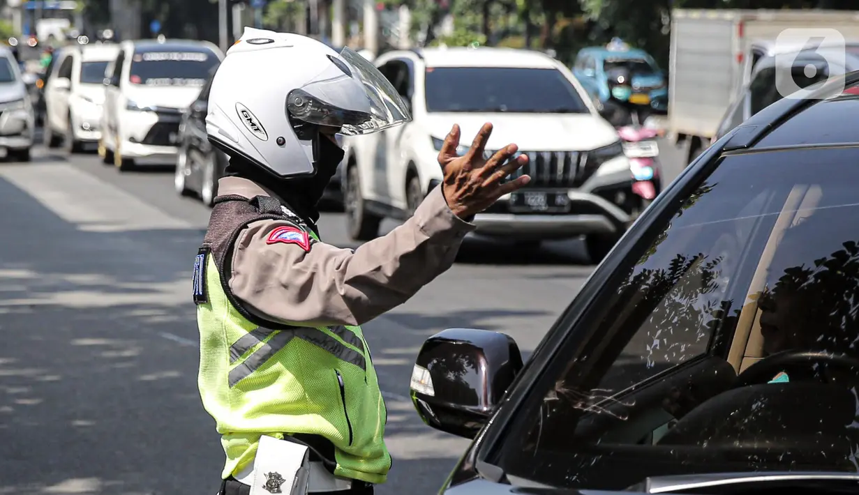 Polisi lalu lintas berkomunikasi dengan pengendara mobil saat Operasi Zebra Jaya 2022 di Jakarta, Selasa (4/10/2022). Operasi Zebra Jaya dilaksanakan pada tanggal 3 hingga 17 Oktober untuk menekan jumlah pelanggaran lalu lintas. (Liputan6.com/Faizal Fanani)