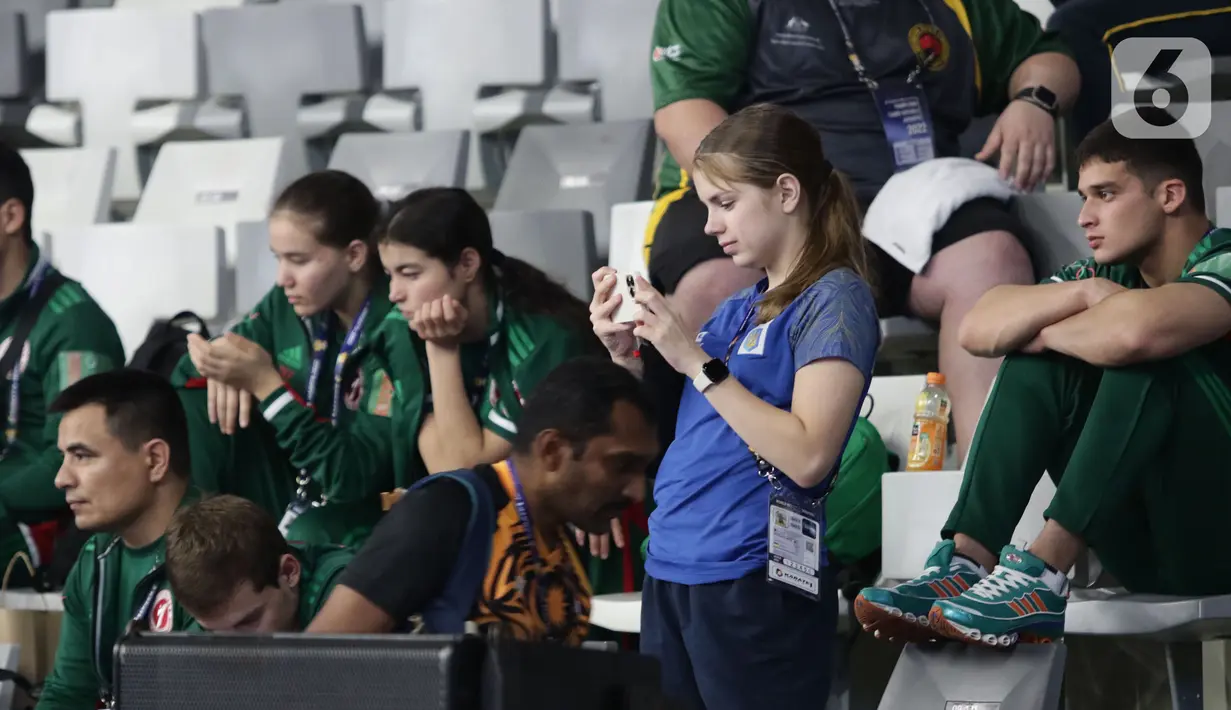 Atlet karate dari berbagai negara mengabadikan rekannya yang bertanding di Kejuaraan Karate Internasional WKF Series A 2022 di Istora Gelora Bung Karno, Jakarta, Jumat (18/11/2022). Indonesia mengirimkan 168 atlet dari klub yang berasal dari judo/klub, Pengprov FORKI, serta team nasional sebanyak 17 atlet. (Liputan6.com/Helmi Fithriansyah)