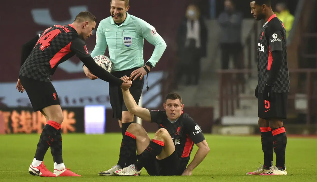 Pemain Liverpool James Milner (tengah) mendapat bantuan untuk berdiri dari rekannya Jordan Henderson saat melawan Aston Villa pada pertandingan putaran ketiga Piala FA di Stadion Villa Park, Birmingham, Inggris, Jumat (8/1/2021). Liverpool menang 4-1. (AP Photo/Rui Vieira)