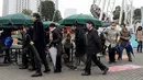 Sejumlah peserta memakai saat mengikuti simulasi evakuasi anti-rudal di taman hiburan Tokyo Dome City, Jepang, (22/1). Di tengah balistik Korea Utara, warga Jepang menggelar simulasi evakuasi anti-rudal. (AFP Photo/Toshifumi Kitamura)