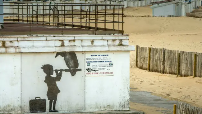 Lukisan mural karya Bansky di Calais yang menggambarkan anak sedang mengamati laut menggunakan teleskop. (Sumber AFP)