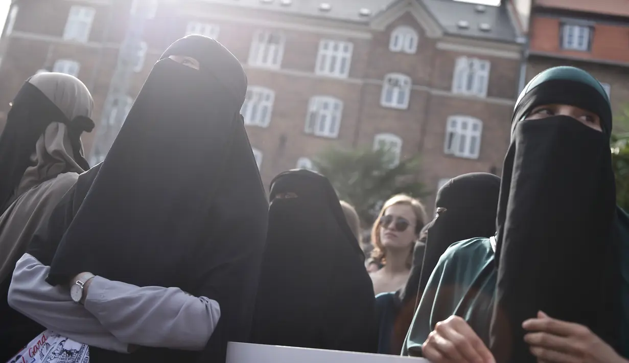 Demonstran melakukan protes larangan penggunaan cadar di Kopenhagen, Rabu (1/8). Parlemen Denmark mengesahkan undang-undang yang melarang pengenaan penutup muka bagi perempuan di tempat umum pada Mei 2018. (Mads Claus Rasmussen/Ritzau Scanpix via AP)