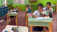 Video viral menampilkan seorang siswi 10 tahun ikut ujian sambil gendong adik. (sumber: TikTok/yingggzz via World of Buzz)