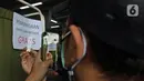 Calon penumpang memotret hasil tes antigen di Stasiun Manggarai, Jakarta, Senin (21/6/2021). PT KAI Commuter melakukan tes antigen secara acak kepada penumpang KRL guna mencegah penyebaran COVID-19. (Liputan6.com/Herman Zakharia)