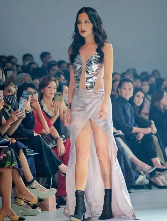 Ia mengenakan outfit terbuka dengan atasan cut out silver, dan kain sebagai bawahan. Mana momen Sophia Latjuba melenggang di runway yang jadi favoritmu, Sahabat FIMELA? [Foto: InstagraM/jfwofficial]
