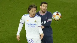 Gelandang Real Madrid Luka Modric berebut bola dengan penyerang Paris Saint Germain (PSG) Lionel Messi pada leg pertama babak 16 besar Liga Champions di Stadion Parc des Princes, Rabu dini hari WIB (16/2/2022). PSG susah payah kalahkan Real Madrid 1-0. (AP Photo/Francois Mori)