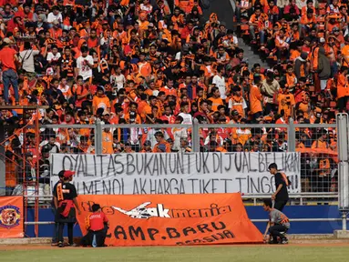 Suporter Persija membentangkan spanduk protes kenaikan harga tiket saat laga Persija melawan Persela di Stadion GBK Jakarta, Minggu (1/3/2015). (Liputan6.com/Helmi Fithriansyah)