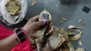 Pekerja memotong daun tendu untuk membuat rokok linting atau beedi di sebuah pabrik di Nizamabad, India, 10 Oktober 2019. Bila sebungkus rokok normal berisi 20 batang adalah 150 rupee, harga sebungkus beedi berisi 15 rokok linting hanya 5 rupee. (NOAH SEELAM/AFP)