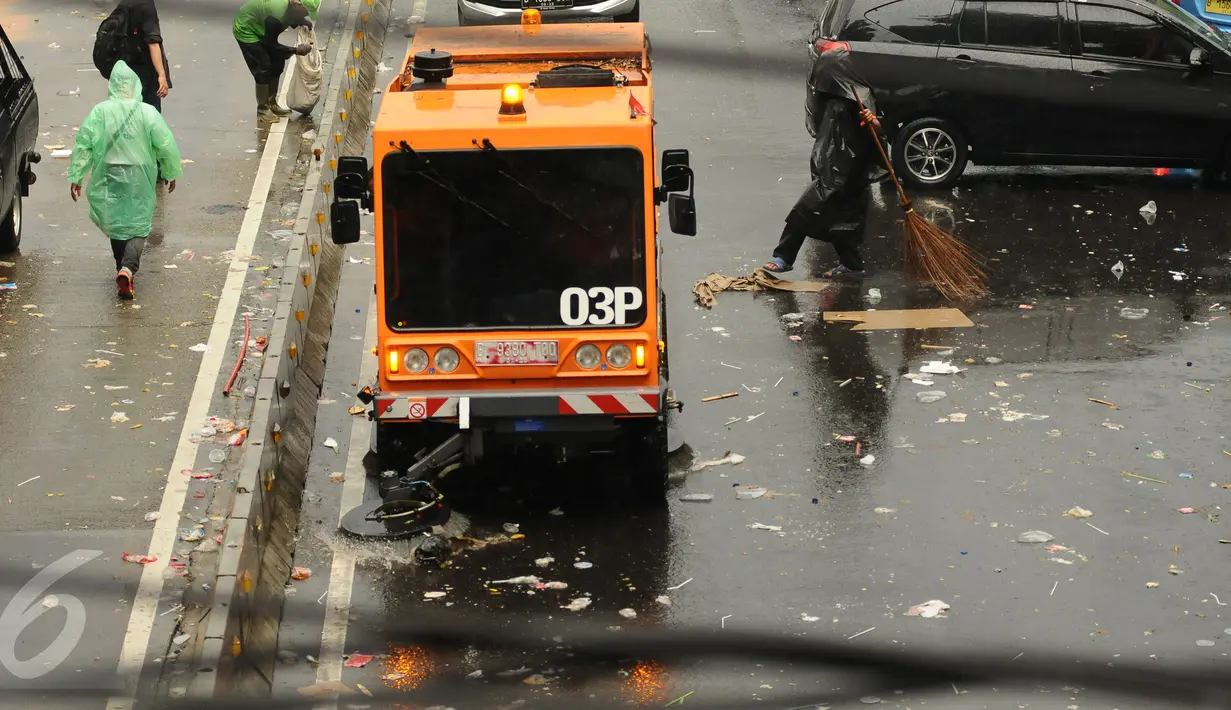 Kendaraan penyapu jalan diterjunkan untuk membantu membersihkan jalan Medan Merdeka Barat dari ceceran sampah usai perayaan hari Buruh Internasional 2017, Jakarta, Senin (5/1). (Liputan6.com/Helmi Fithriansyah)