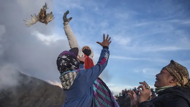 FOTO: Upacara Yadnya Kasada, Suku Tengger Larung Sesajen ke Kawah Gunung Bromo