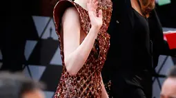 Aktris Emma Stone menyapa fans saat tiba menghadiri perhelatan Piala Oscar 2019 di Teater Dolby di Los Angeles, AS (24/2). Emma Stone tampil cantik mengenakan gaun emas seperti sarang lebah Louis Vuitton. (AFP Photo/Eric Jamison)