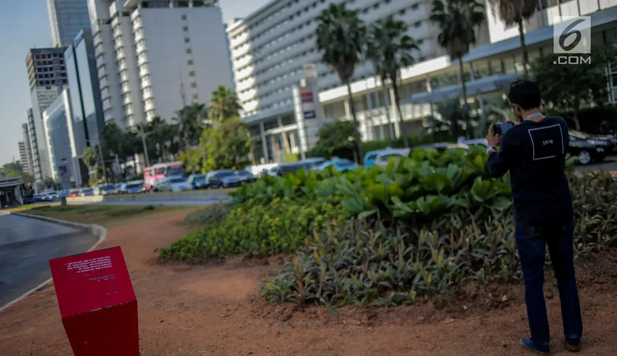 Warga mengambil gambar jalur hijau usai pembongkaran instalasi bambu Getah Getih di Bundaran HI, Jakarta, Kamis (18/7/2019). Masyarakat kini bisa melihat jelas Monumen Selamat Datang dari halte transjakarta Bundaran HI tanpa terhalang karya seni bernilai Rp550 juta itu. (Liputan6.com/Faizal Fanani)