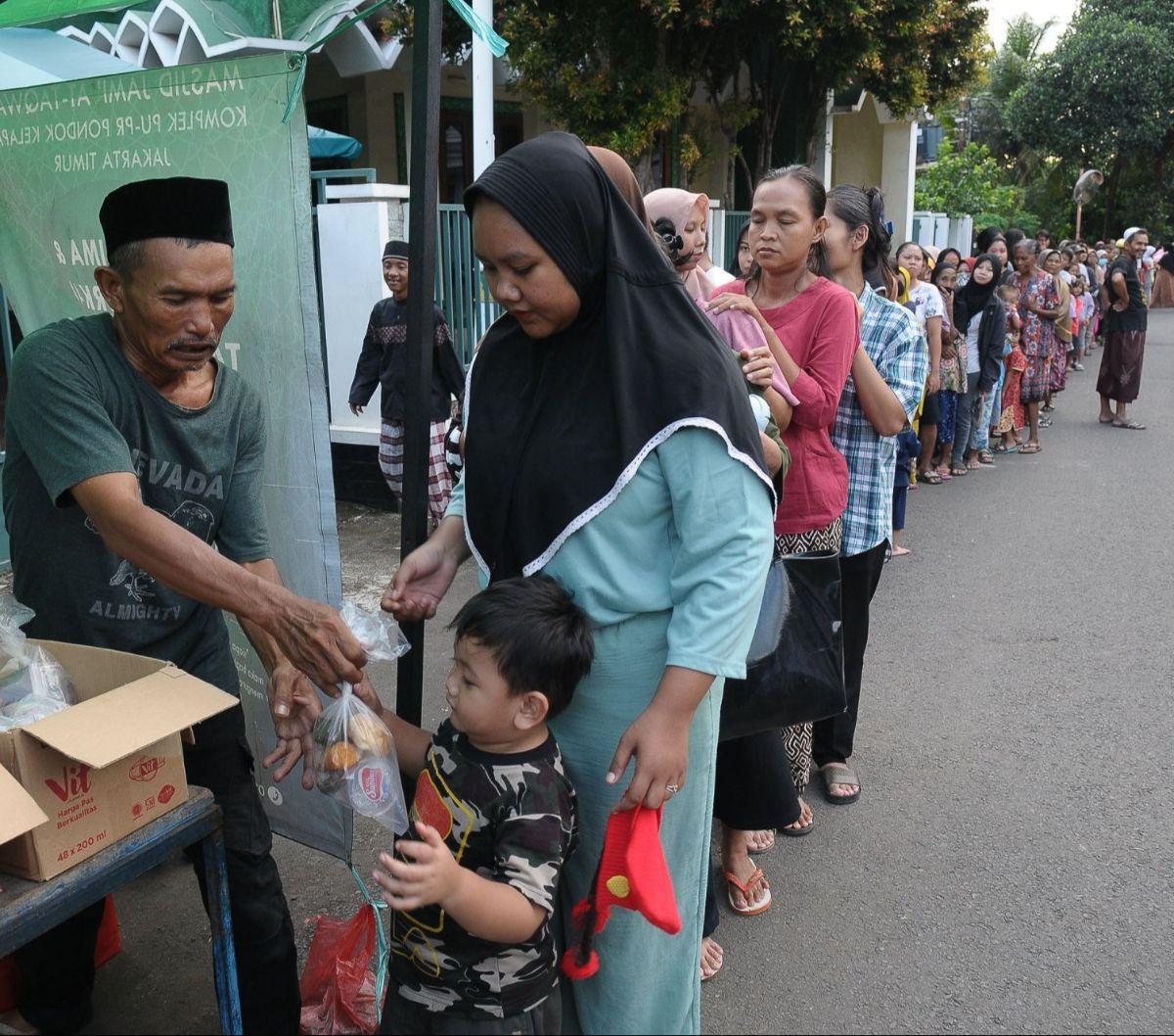Warga menerima takjil gratis yang dibagikan Dewan Kemakmuran Masjid (DKM)&nbsp;Masjid At-Taqwa, Pondok Kelapa, Jakarta, Jumat (22/3/2024). Setiap hari menjelang waktu berbuka puasa, pengurus Masjid At-Taqwa membagikan ratusan paket takjil gratis berupa be