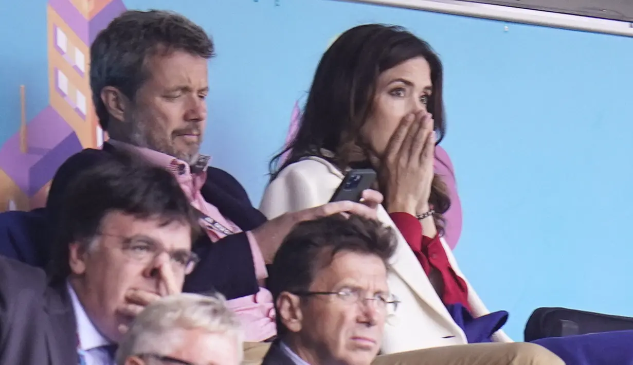 Putra Mahkota Frederik dan Putri Mahkota Mary dari Denmark bereaksi setelah gelandang Denmark Christian Eriksen pingsan di lapangan pada laga Denmark vs Finlandia di Grup B Euro 2020 di Parken Stadium, Copenhagen, Sabtu (12/6/2021). (Liselotte Sabroe / Ritzau Scanpix / AFP)