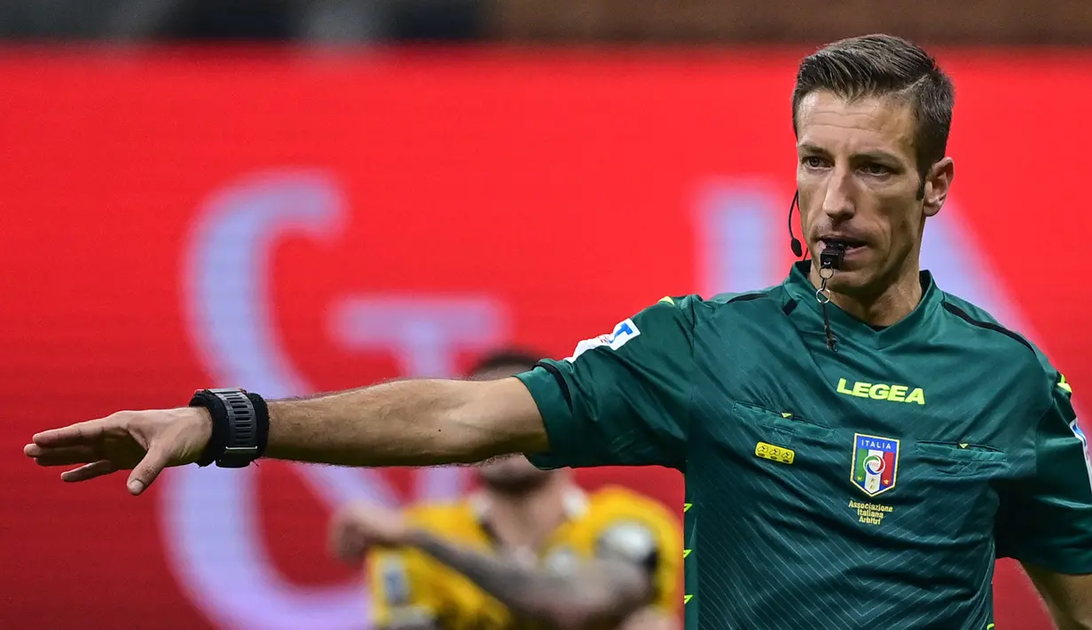 Wasit Davide Massa memberikan tendangan penalti kepada AC Milan di masa injury time saat menghadapi Udinese dalam laga lanjutan Liga Italia 2020/21 pekan ke-25 di San Siro Stadium, Rabu (3/3/2021). AC Milan bermain imbang 1-1 dengan Udinese. (AFP/Miguel Medina)