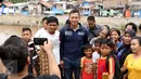 Bakal Calon Gubernur DKI, Agus Harimurti Yudhoyono berfoto bersama sejumlah warga saat mengunjungi kawasan Bukit Duri, Jakarta, Kamis (20/10). Kunjungan Agus Yudhoyono untuk melihat langsung kondisi warga yang terkena gusuran (Liputan6.com/Gempur M Surya)