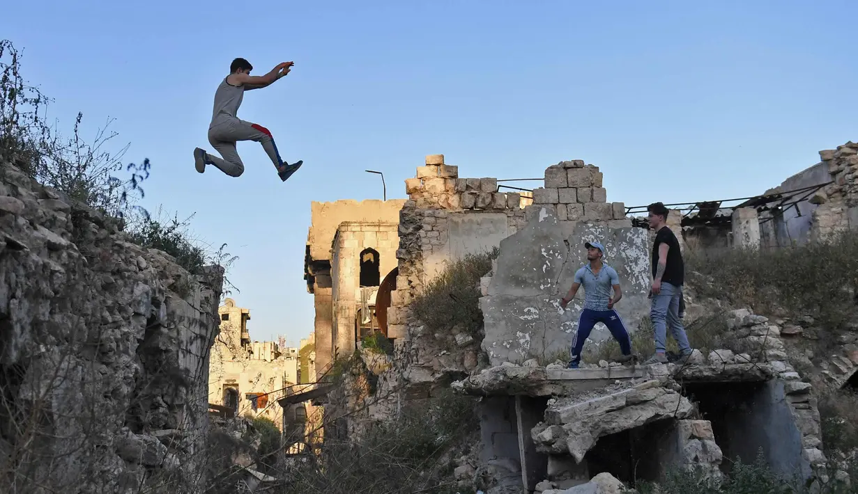 Sejumlah pemuda berlatih parkour di Aleppo, Suriah, (7/4). Setelah pemerintah Suriah mengambil alih kendali penuh Aleppo dari pasukan pemberontak Desember 2016, beberapa pemuda kini menyalurkan hobinya, yaitu parkour.  (AFP Photo/George Ourfalian)