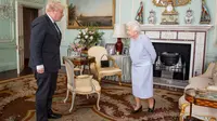 Ratu Elizabeth II menyapa Perdana Menteri Inggris Boris Johnson selama audiensi di Istana Buckingham di London pusat pada 23 Juni 2021. (Dominic Lipinski / POOL / AFP)