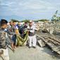Warga mengevakuasi kantong jenazah berisi jasad korban tsunami di Palu, Sulawesi Tengah , Sabtu (29/9). Gelombang tsunami setinggi 1,5 meter yang menerjang Palu terjadi setelah gempa bumi mengguncang Palu dan Donggala. (AP Photo/Rifki)