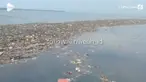 Seorang warga merekam keadaan lautan di sekitar Pulau Pari, Kepulauan Seribu yang penuh sampah berbau busuk dan tercampur limbah aspal.