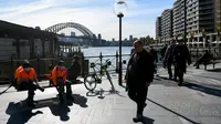 Orang-orang terlihat dengan dan tanpa masker di Circular Quay, Sydney, Selasa (6/7/2021). PM negara bagian New South Wales Gladys Berejiklian mengutarakan pihaknya akan memutuskan apakah akan memperpanjang lockdown di Sydney atau tidak yang harusnya berakhir pada 9 Juli 2021. (Bianca De Marchi/AFP)