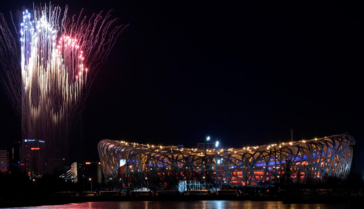 Pemandangan umum kembang api dalam bentuk Cincin Olimpiade menerangi langit di atas Stadion Nasional, yang dikenal sebagai Stadion Bird's Nest, selama upacara pembukaan Olimpiade Musim Dingin Beijing 2022 di Beijing, pada 4 Februari 2022. (AFP/Sebastian Bozon)