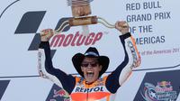Marc Marquez mengangkat pialanya setelah berhasil finish diurutan pertama pada MotoGP Amerika di Austin, Texas, (23/4). Valentino Rossi meraih Posisi kedua dan posisi ketiga ditempati Dani Pederosa. (AP Photo/Eric Gay)