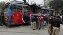 Petugas melakukan pemeriksaan kondisi bus rombongan pegawai Pakistan usai diserang bom di Peshawar, Pakistan, Rabu (16/3). Bus yang membawa rombongan pegawai pemerintah ini menewaskan setidaknya 10 orang dan 27 lainnya terluka. (REUTERS/Fayaz Aziz)