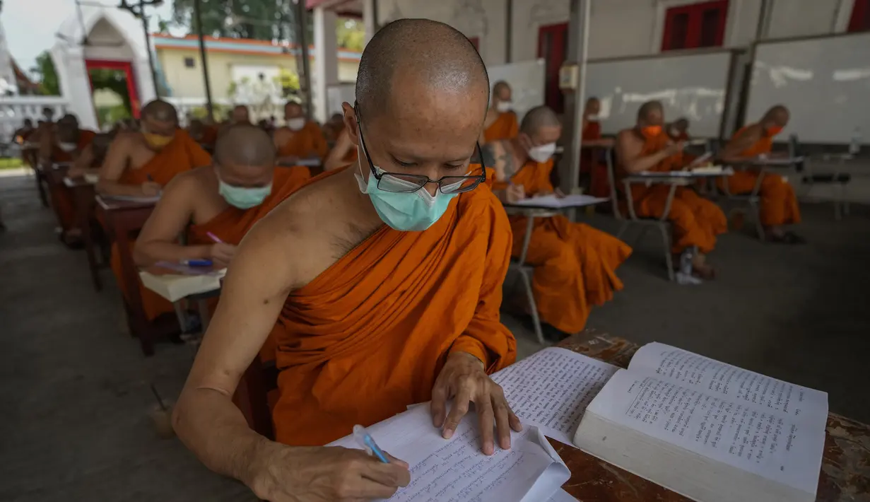 Sejumlah Biksu Buddha memakai masker untuk membantu melindungi diri dari virus corona, mengikuti tes bahasa Pali liturgi di Wat Molilokayaram di Bangkok, Thailand, Kamis (20/1/2022). (AP Photo/Sakchai Lalit)