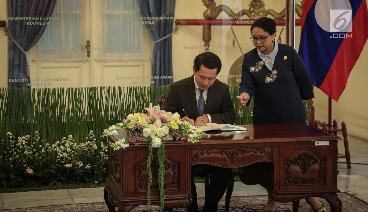 Menlu RI, Retno Marsudi menemani Menlu Laos, Saleumxay Kommasith saat mengisi buku tamu di Gedung Pancasila Kemlu, Kamis (27/7). Kunjungan Menlu Laos bersamaan dengan peringatan 60 tahun Hubungan Diplomatik antara kedua negara (Liputan6.com/Faizal Fanani)