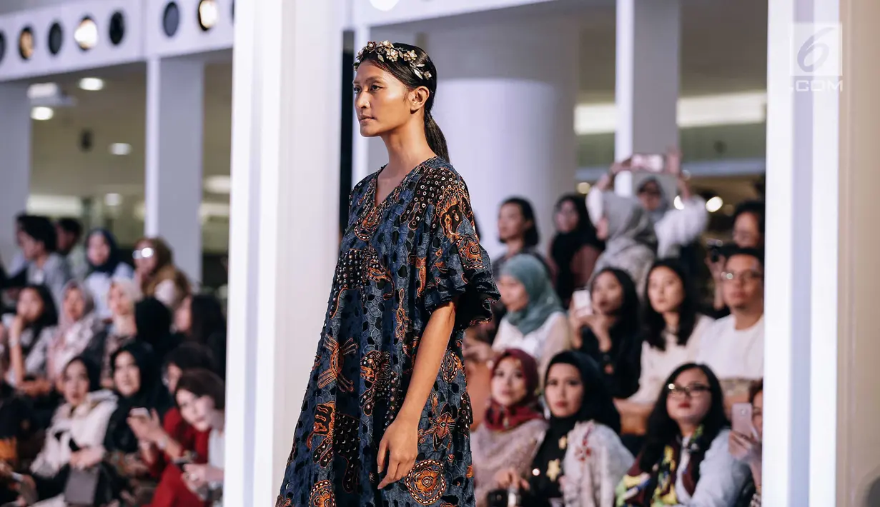 Seorang model menjadi pusat perhatian saat mengenakan busana rancangan Iwan Tirta Private Collection x Mel Ahyar dalam acara Fashion Nation 2018 di Senayan City, Jakarta, Rabu (18/4). (Liputan6.com/Faizal Fanani)