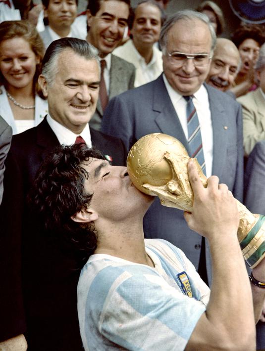 Penyerang Argentina, Diego Maradona, mencium trofi Piala Dunia saat usai mengalahkan Jerman Barat pada laga final Piala Dunia 1986 di Meksiko, (29/6/1986). (Photo by - / AFP)